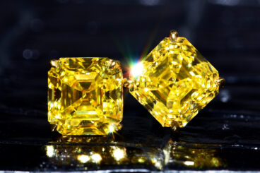 A PAIR OF FANCY VIVID YELLOW DIAMOND STUD EARRINGS, WITH A GIA REPORT